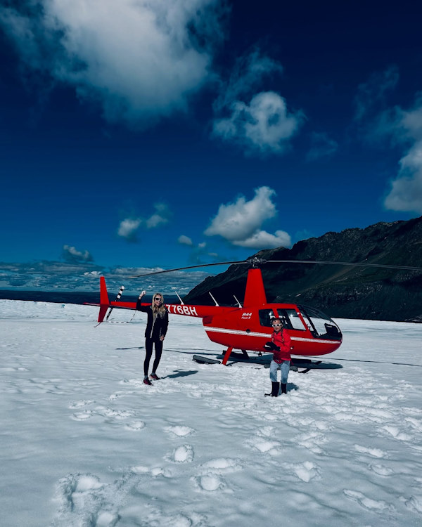 Guests and a red helicopter on a remote Alaska icefield